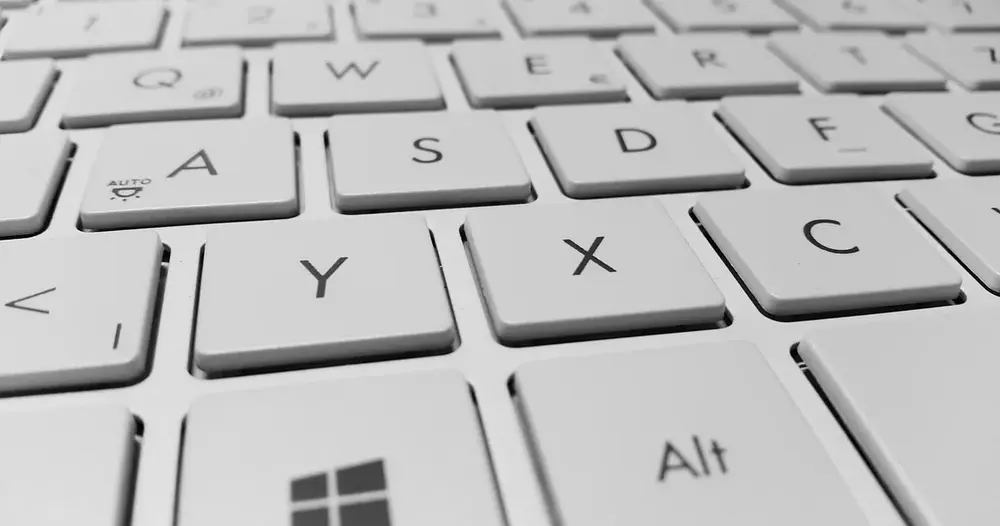 Teclado branco de computador em close, com as teclas Q, W, A, S, X e C, para quem usa contadores de caracteres online
